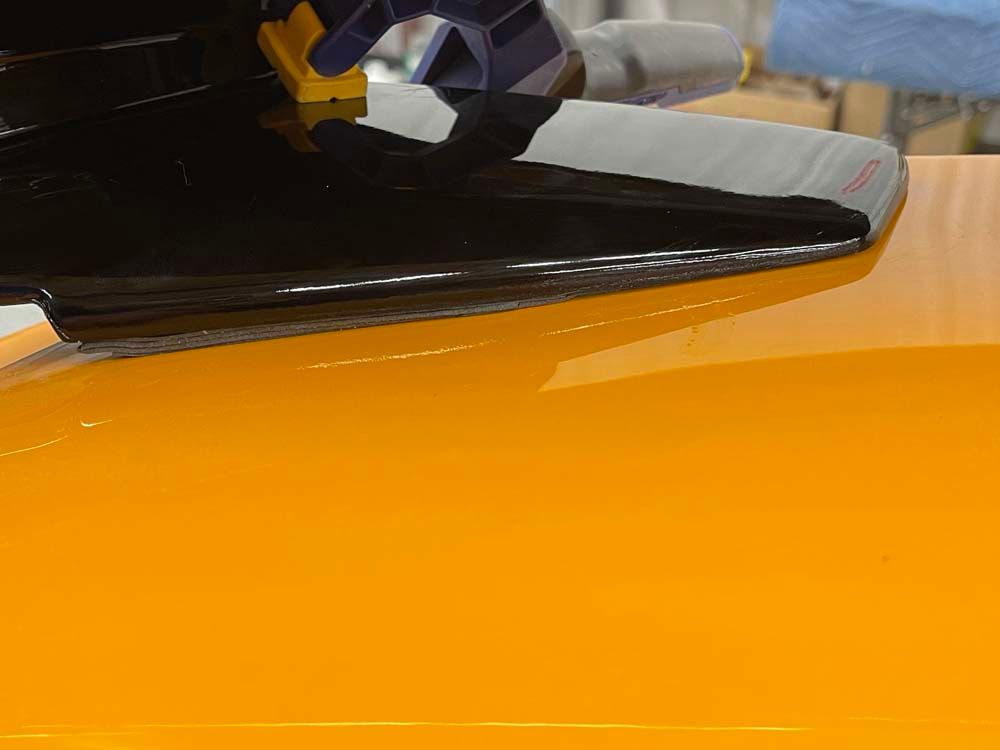 A close up of a black object on a yellow surface.