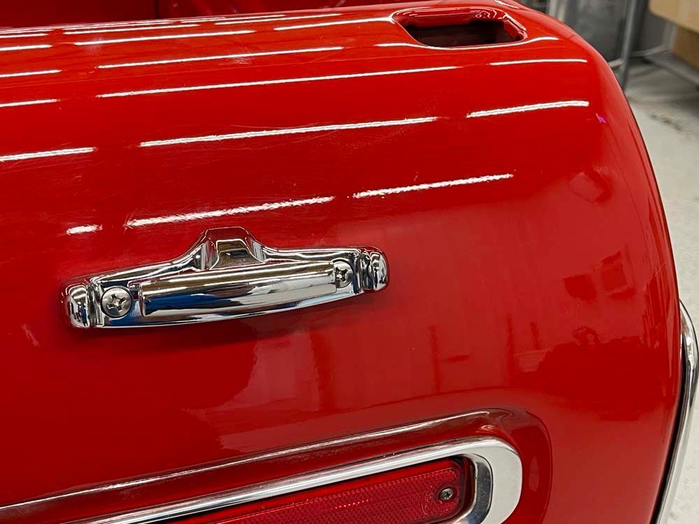 A close up of a red car with a chrome handle