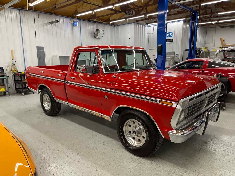 A red pickup truck is parked in a garage.