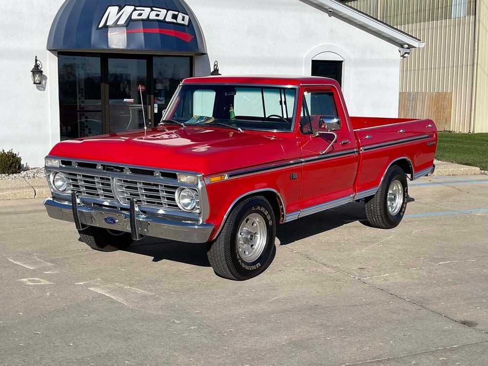 A red pickup truck is parked in front of a building.