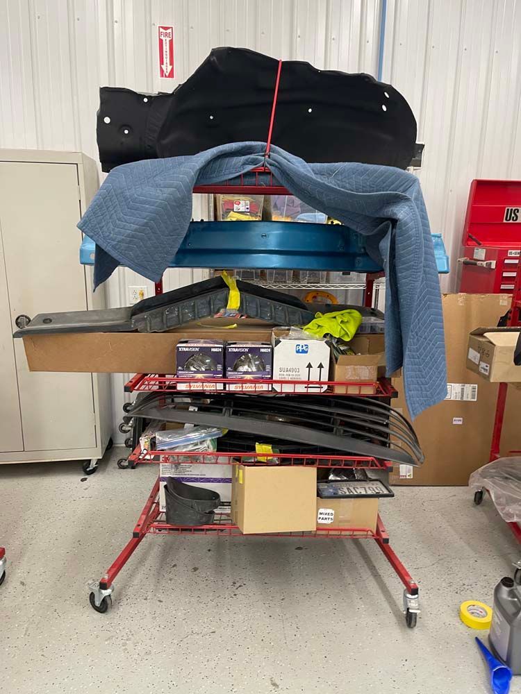 A rack filled with lots of car parts and boxes in a garage.