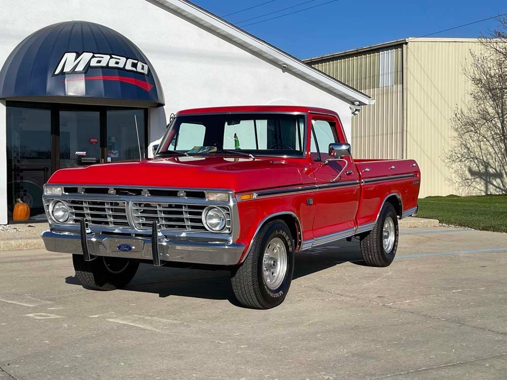 A red pickup truck is parked in front of a building.