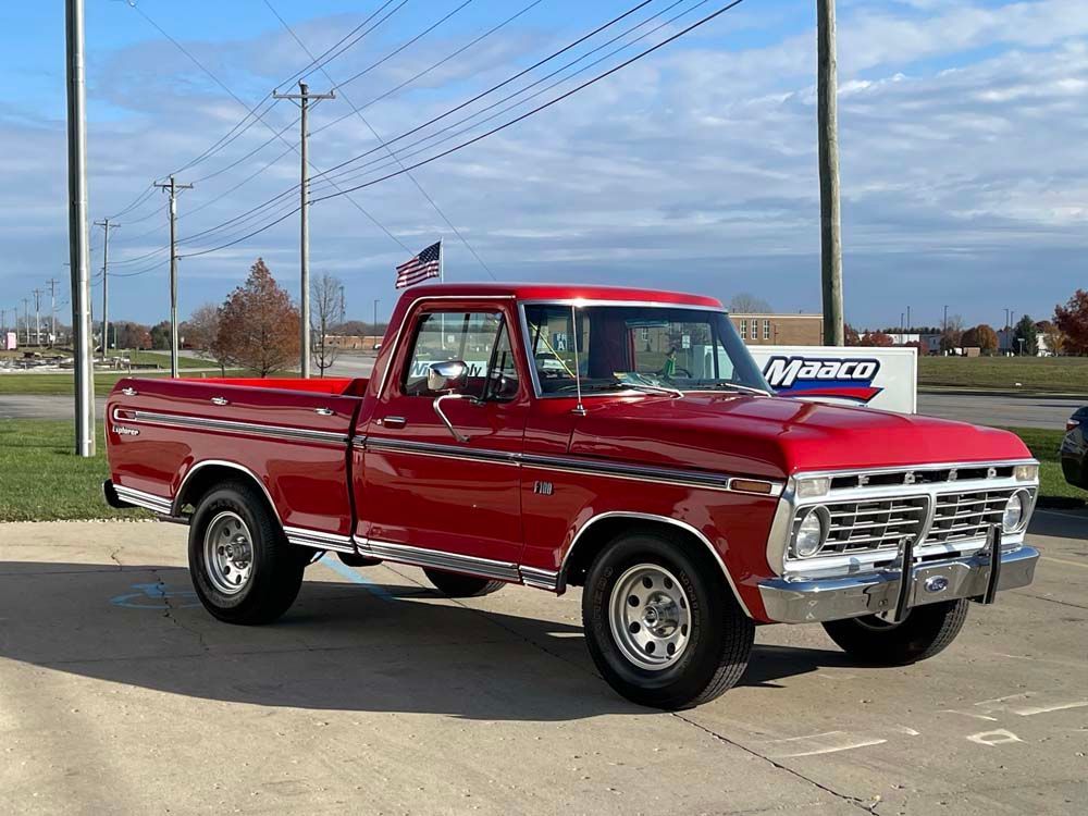 A red pickup truck is parked in a parking lot.
