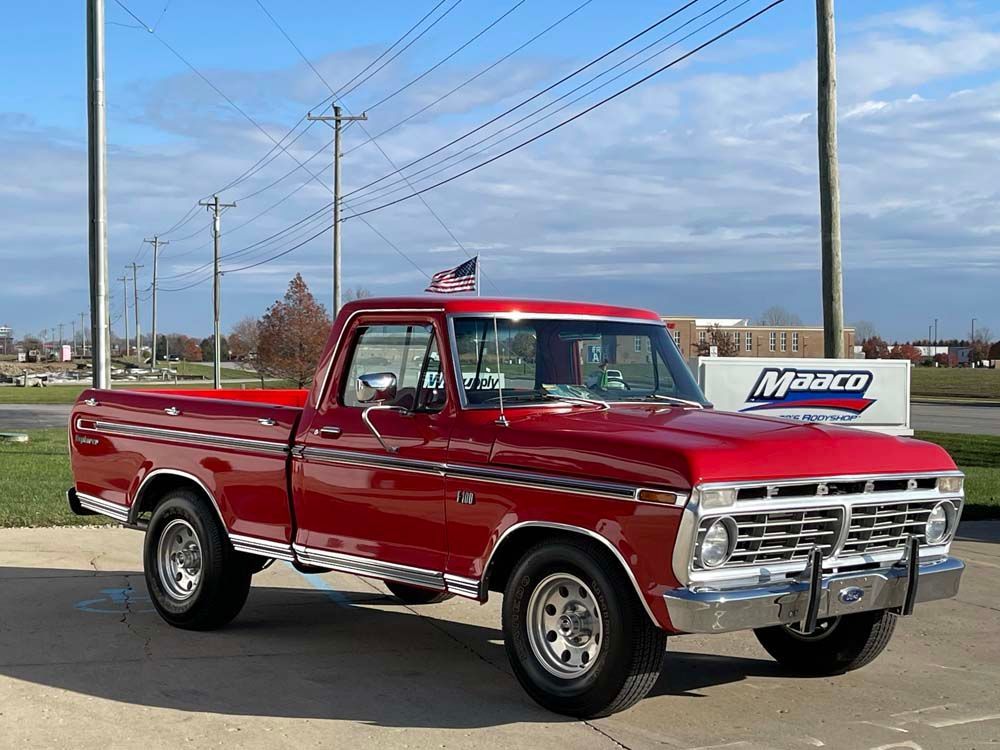 A red pickup truck is parked on the side of the road.