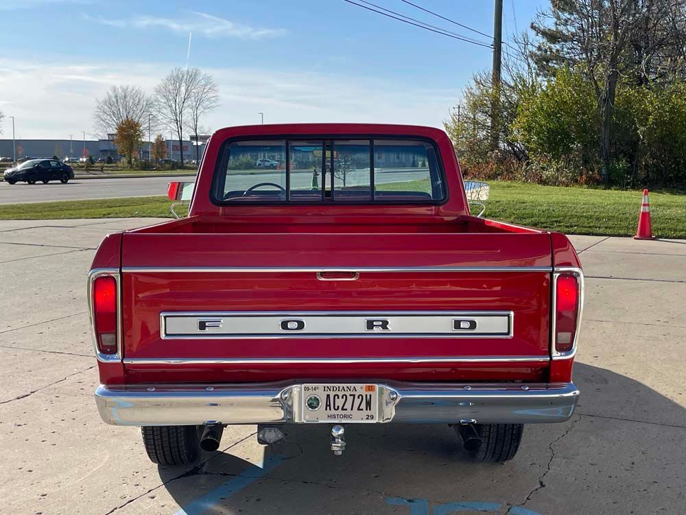 A red ford truck is parked in a parking lot.