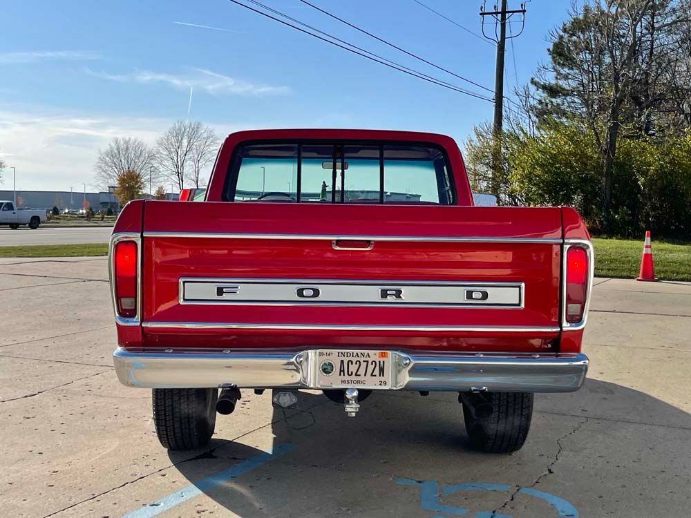 A red ford truck is parked in a parking lot.