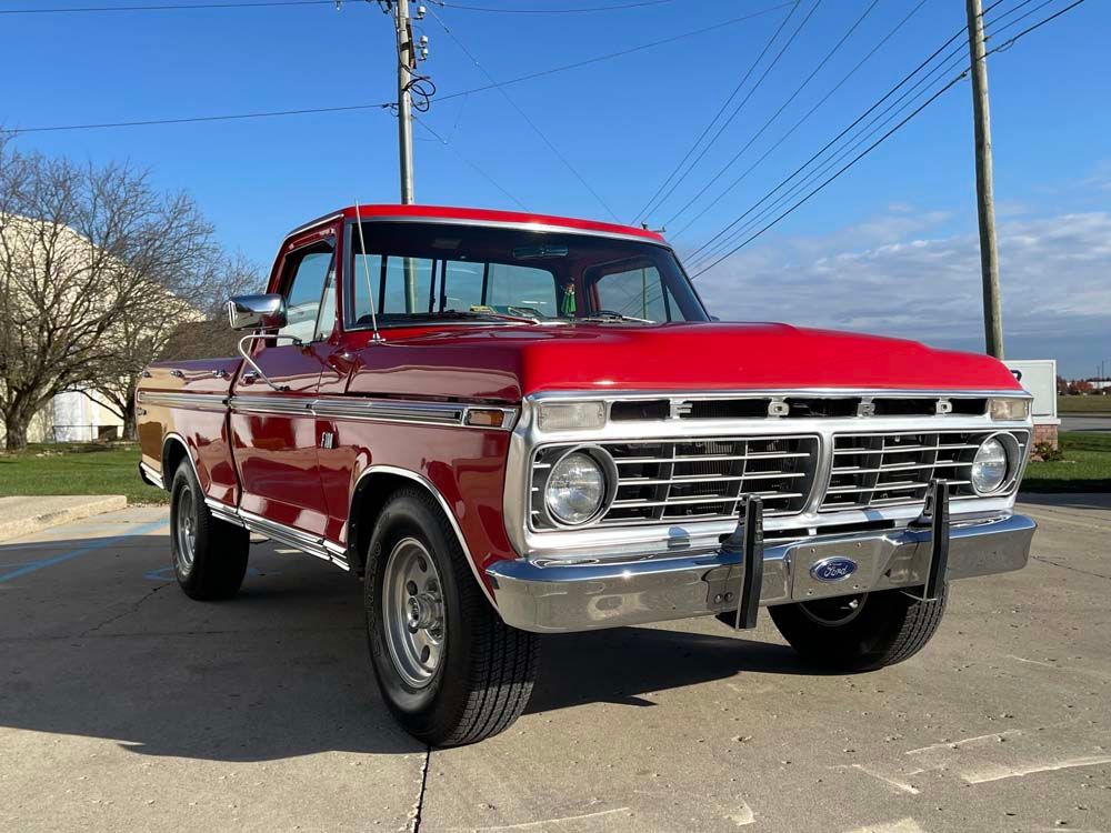 A red ford truck is parked in a parking lot.
