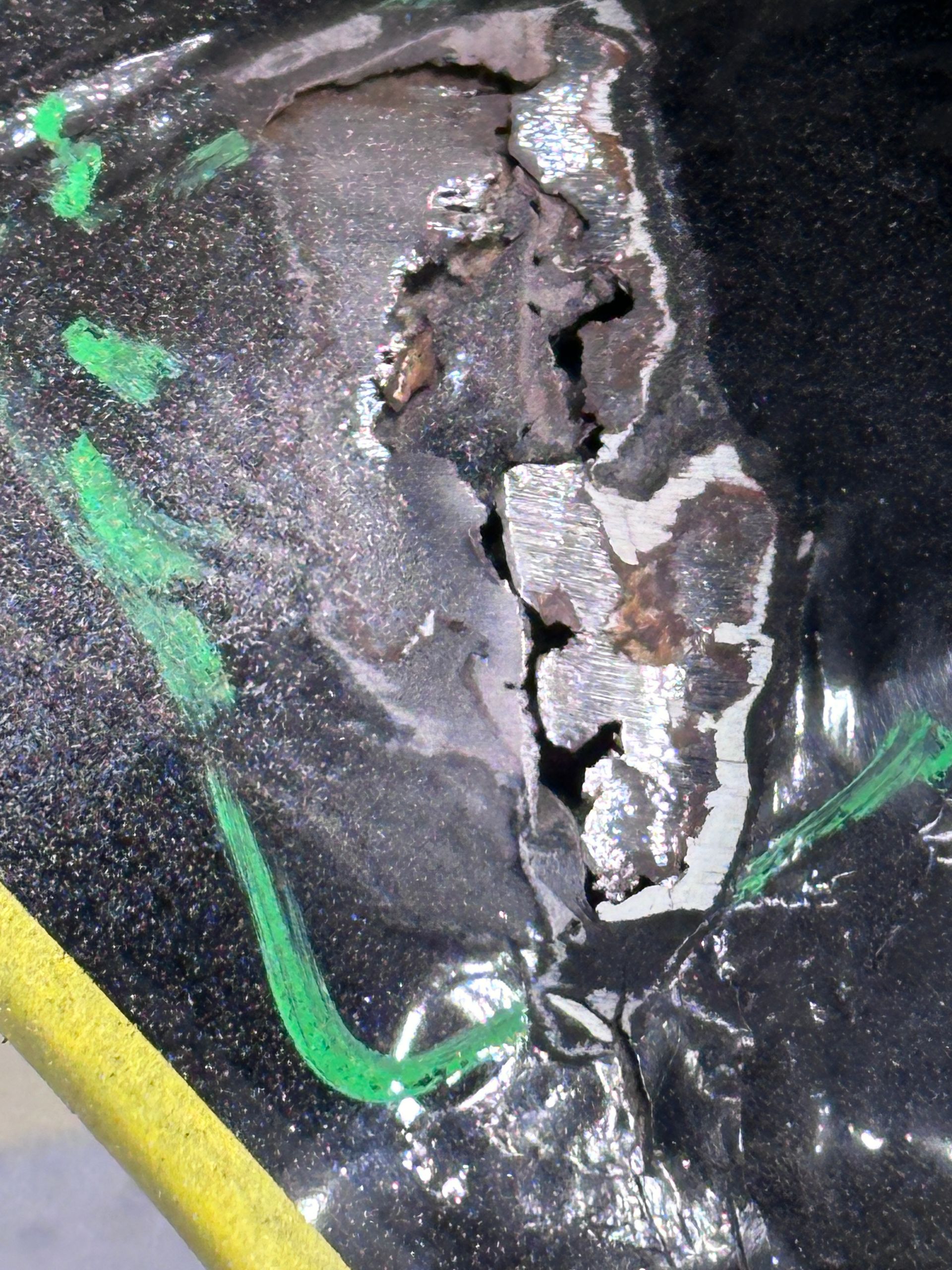 A close up of a piece of metal with a green arrow pointing to it