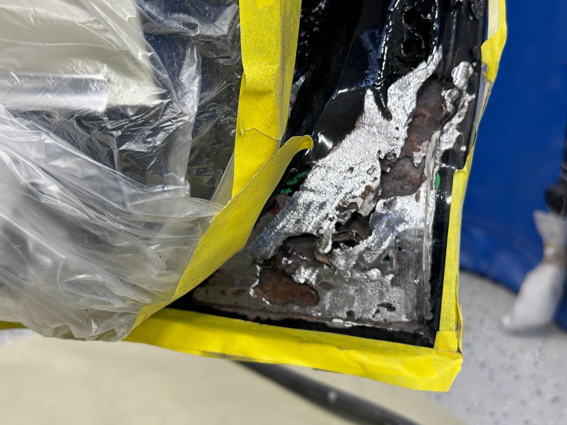 A piece of metal is covered in plastic and yellow tape.