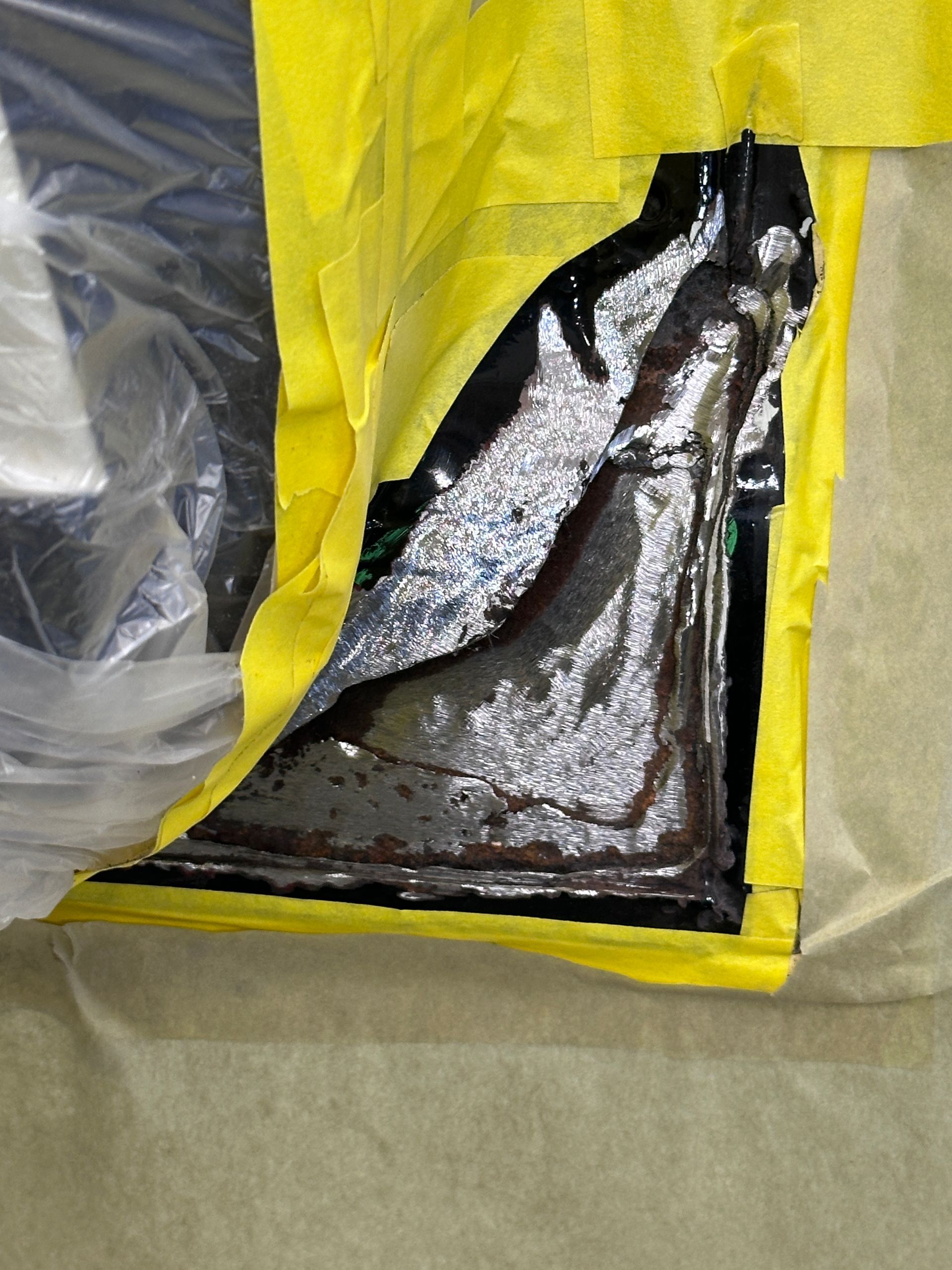 A yellow tarp is covering a piece of metal