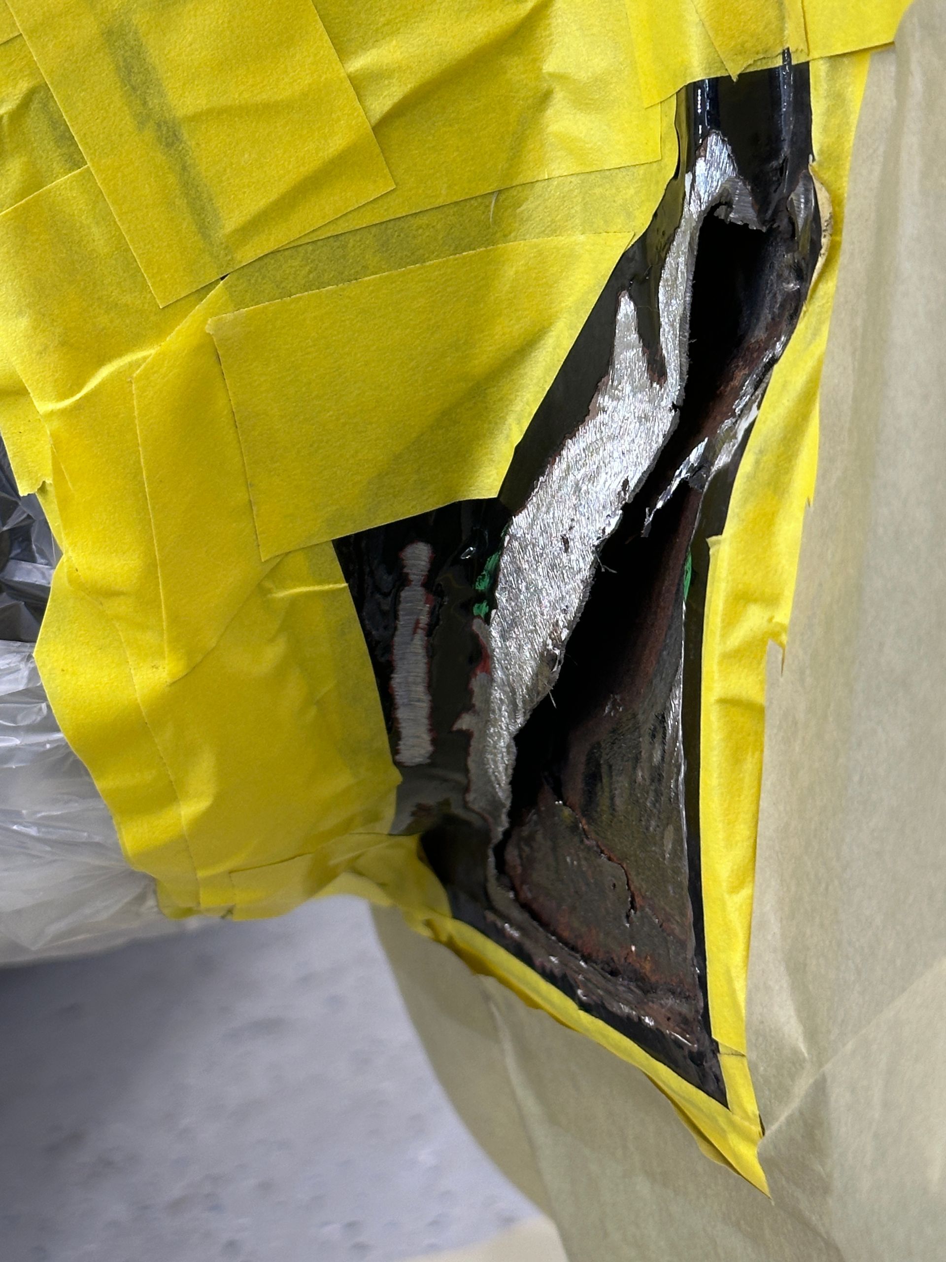 A piece of yellow tape is covering a piece of metal