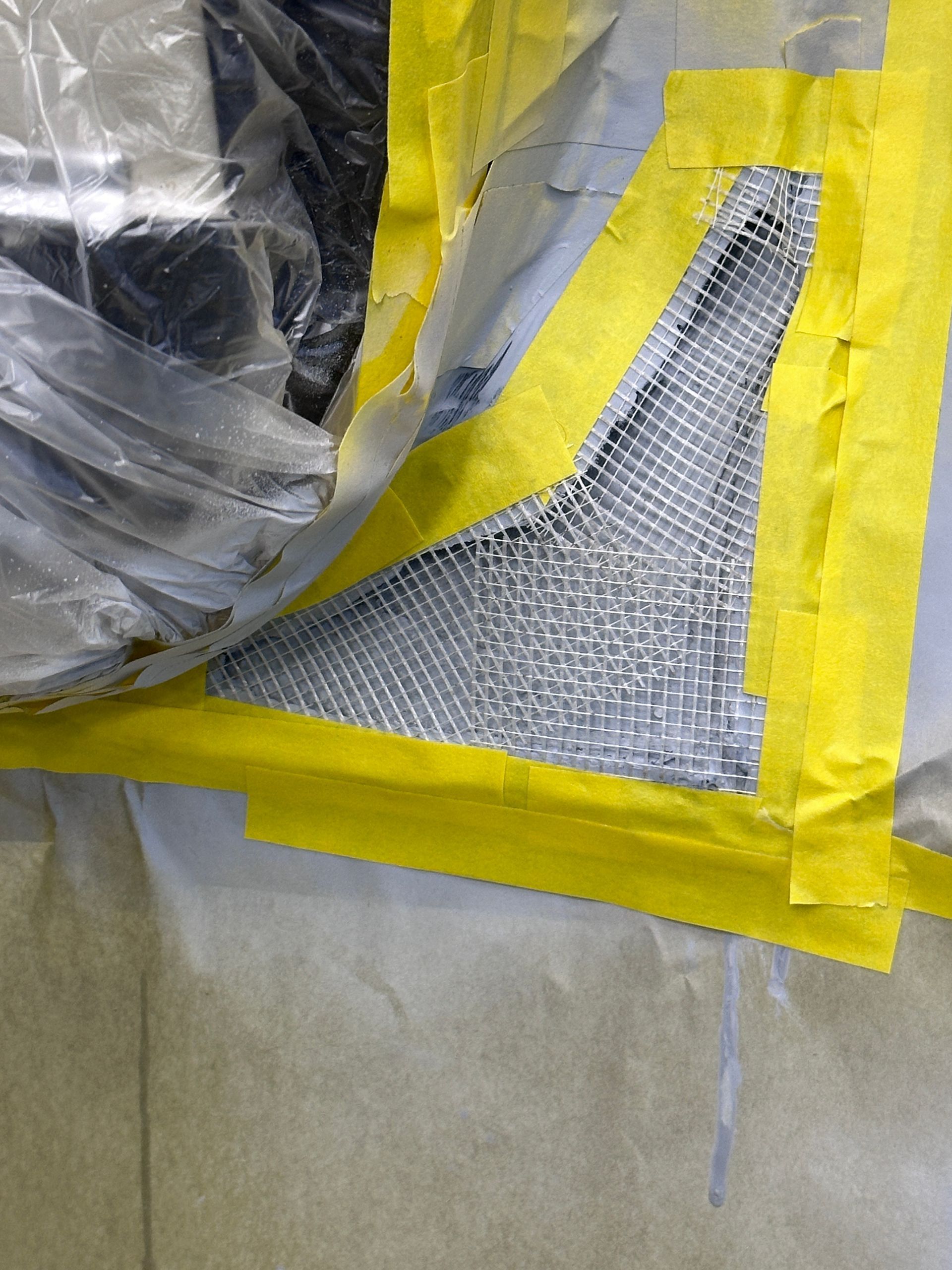 A piece of plastic is taped to a piece of metal