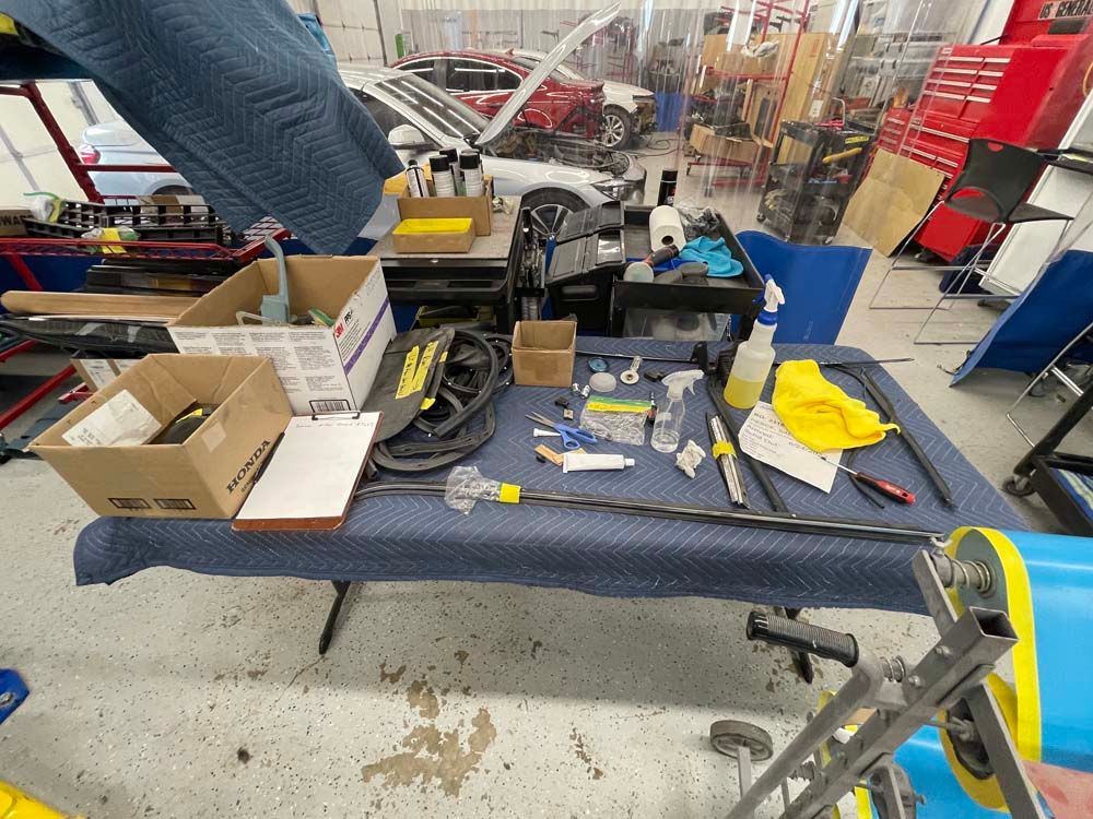 A table with tools and boxes on it in a garage