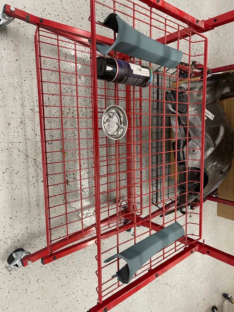A red wire shelf with a lot of items on it