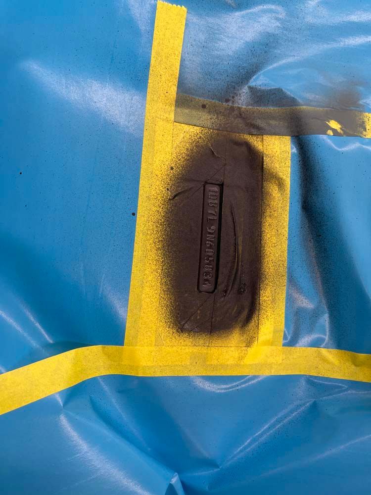 A piece of metal is sitting on top of a blue plastic bag.