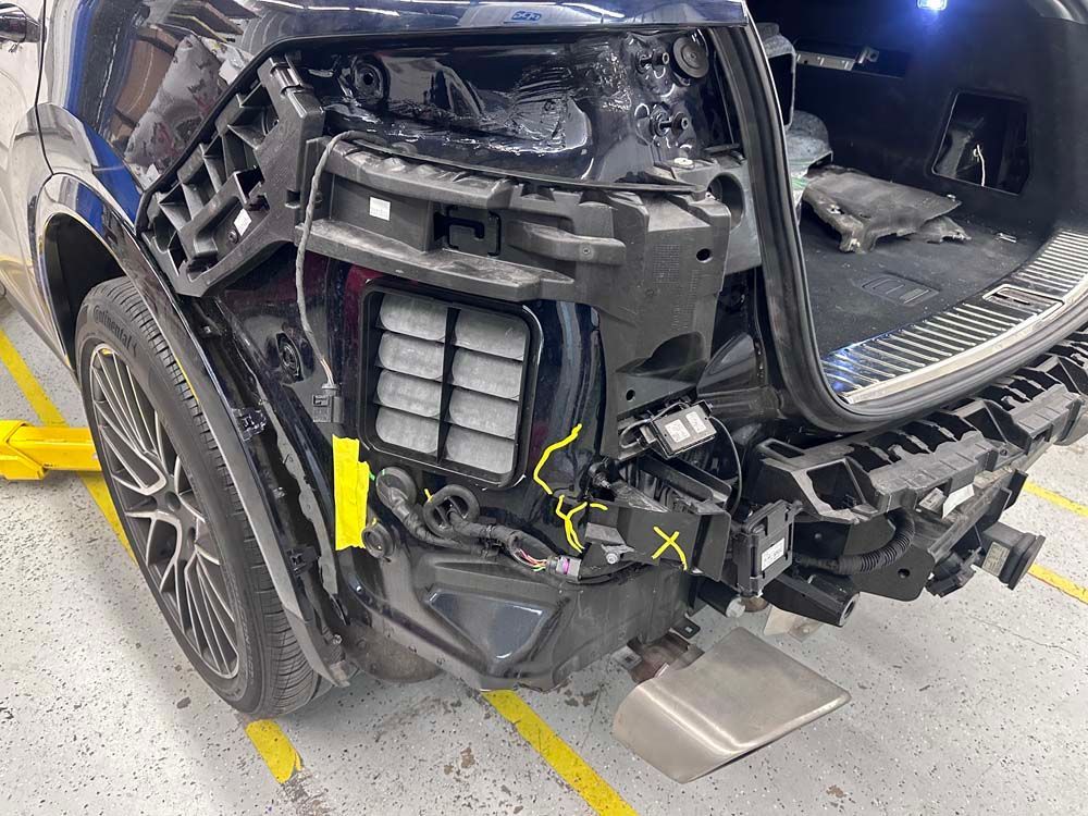 A black car is sitting on a lift in a garage.