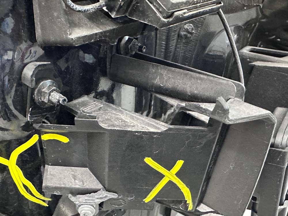 A close up of a piece of metal with a yellow x on it.