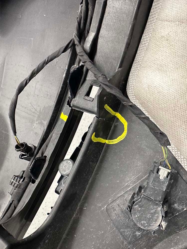 A close up of a bumper with wires attached to it.