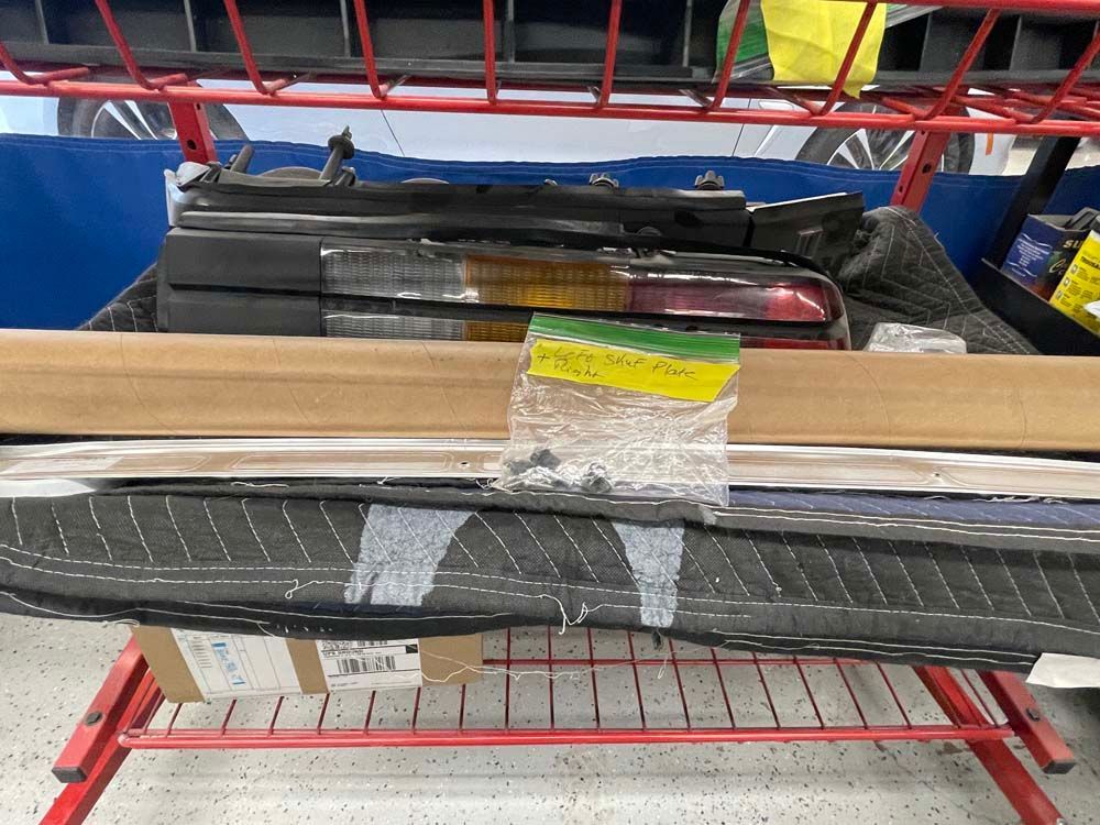 A bunch of car parts are sitting on a red rack.