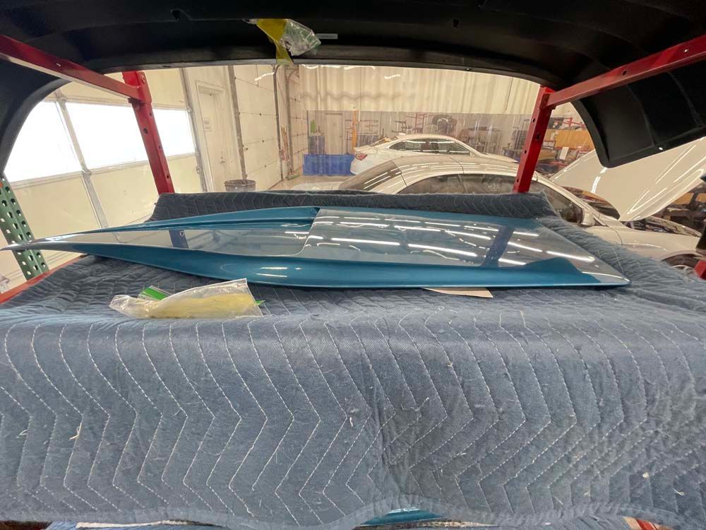 A car is sitting on top of a blanket in a garage.