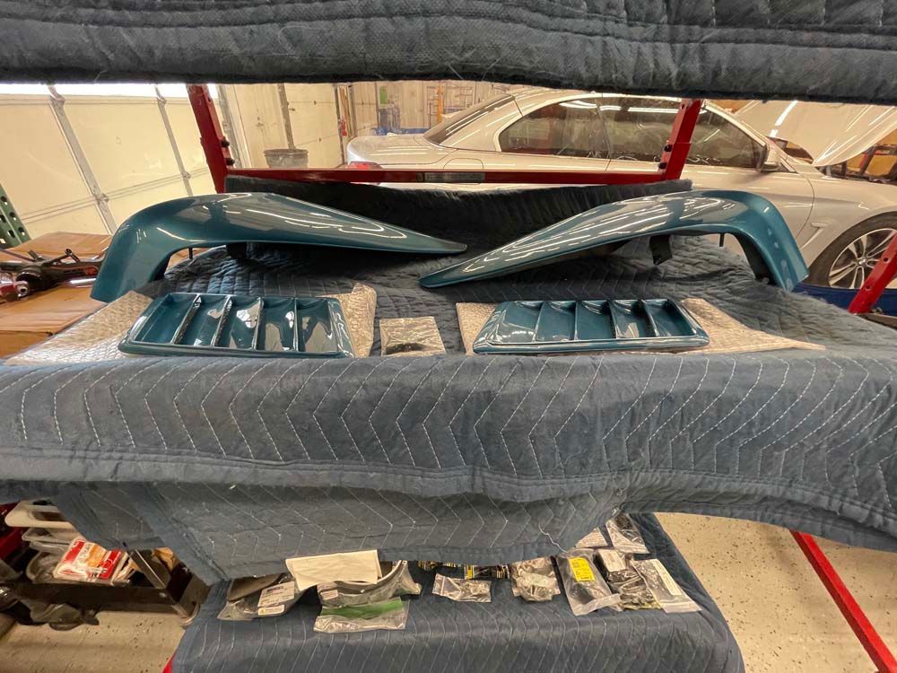 A car is sitting on top of a blanket in a garage.