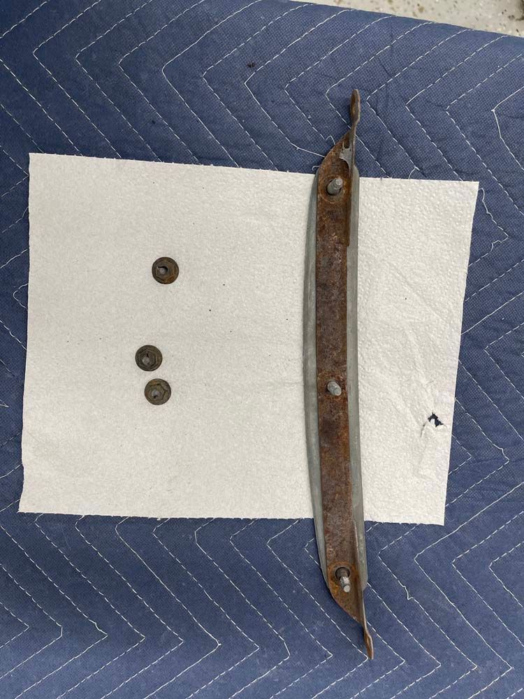 A piece of metal is laying on a piece of paper on a blue blanket.