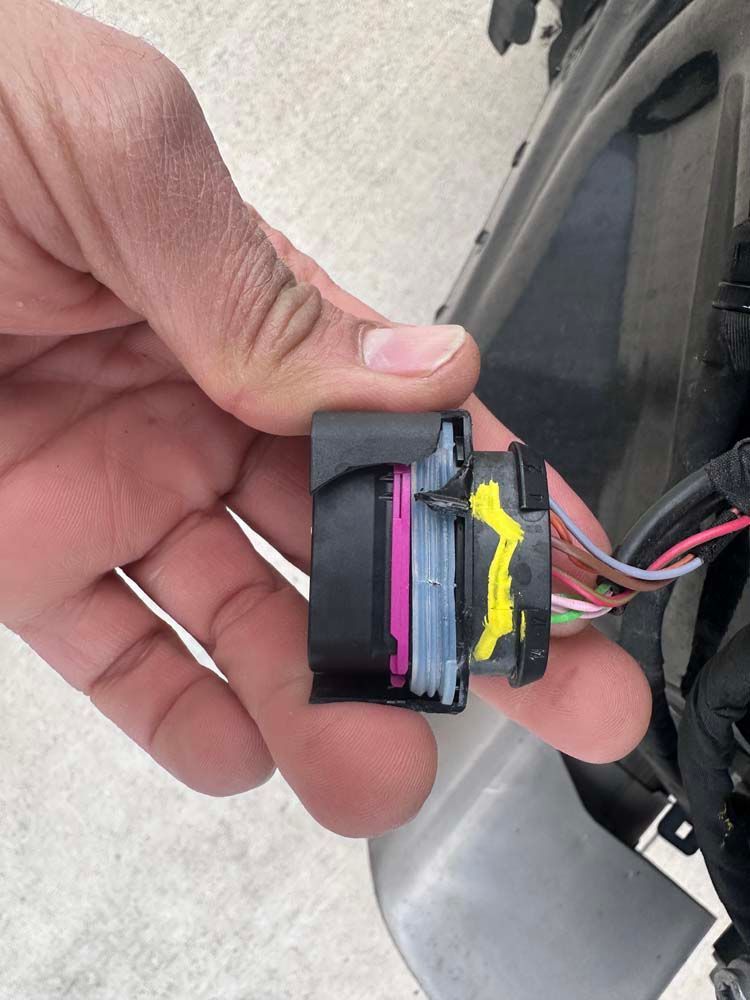 A person is holding a connector in their hand.