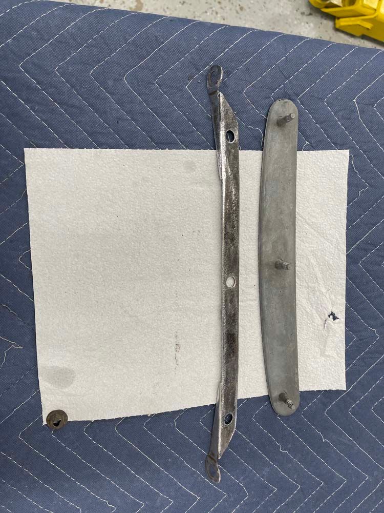 Two metal pieces are laying on a piece of paper