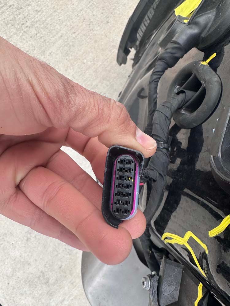 A person is holding a connector in their hand.