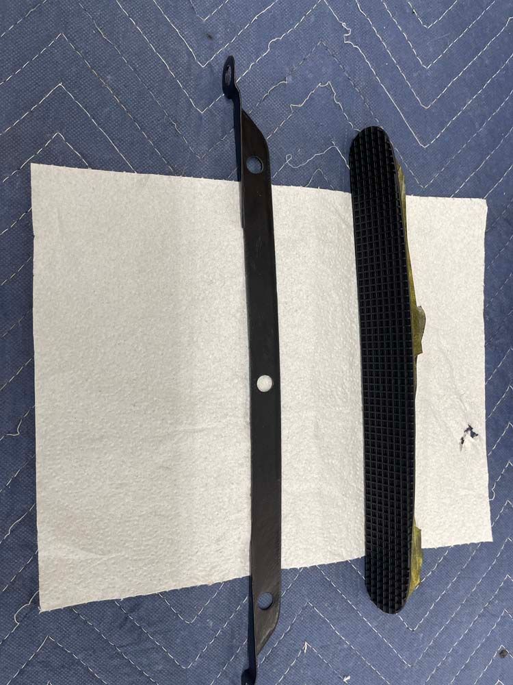 Two pieces of metal are sitting on top of a piece of paper.