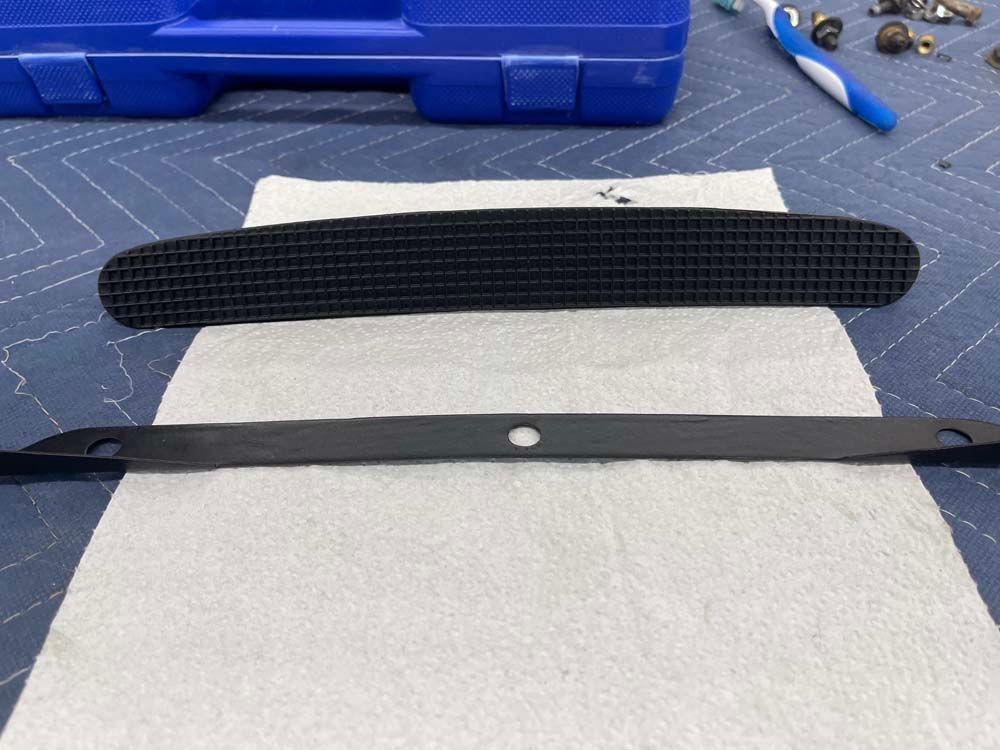 A piece of metal is laying on a piece of paper on a table.