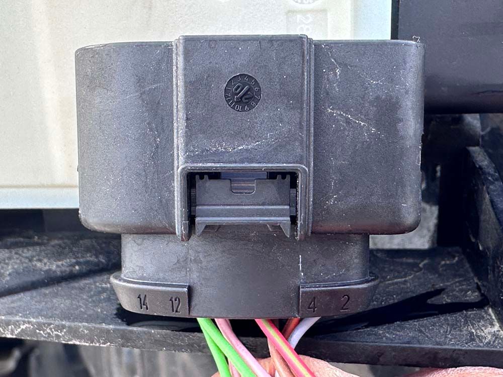 A person is holding a connector with a bunch of wires attached to it.