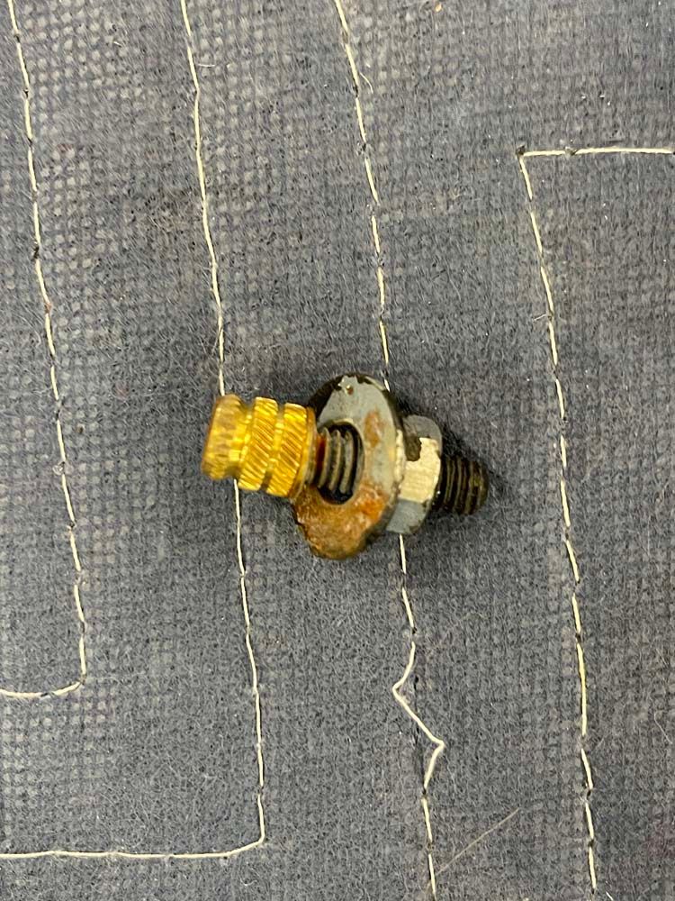 A close up of a screw on a piece of fabric.