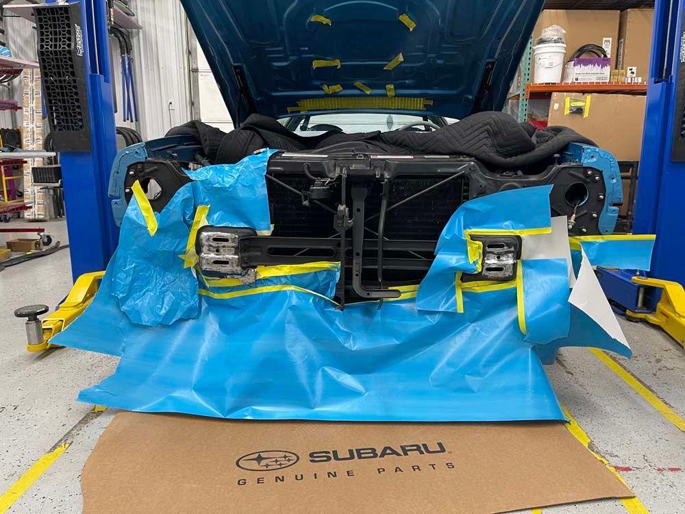 A subaru car is being worked on in a garage