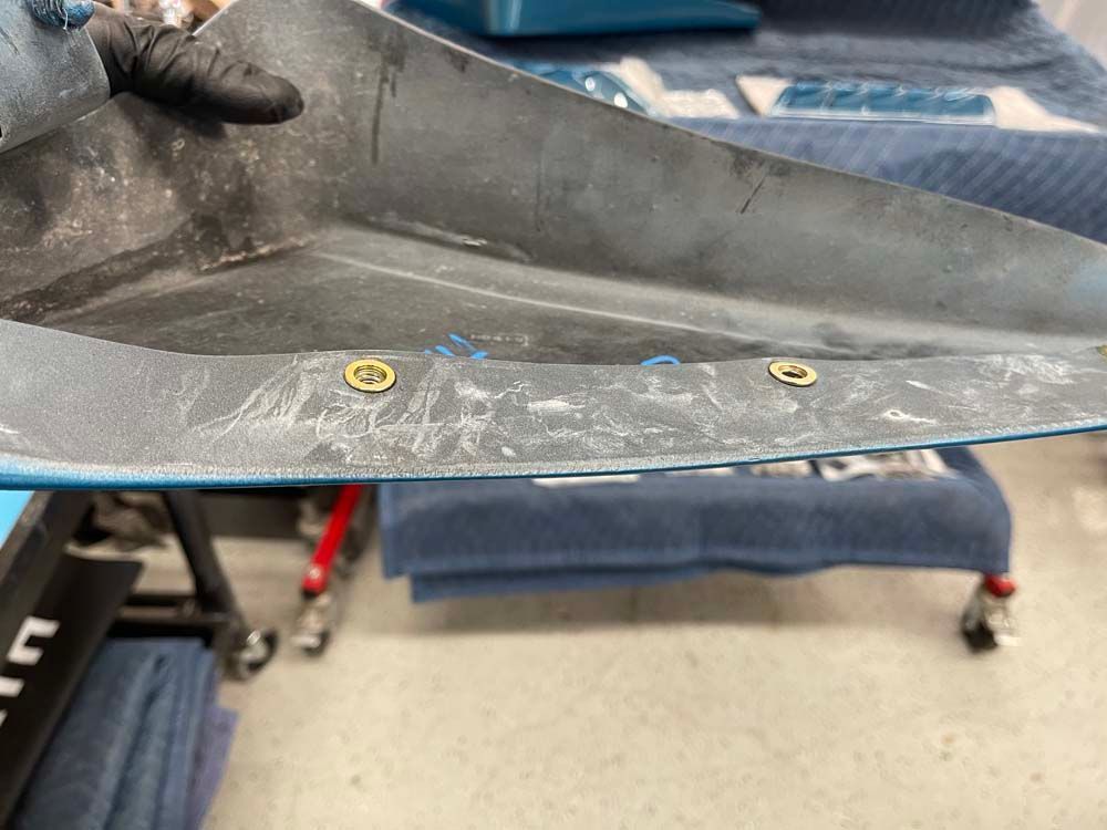 A person is holding a piece of metal in their hand.