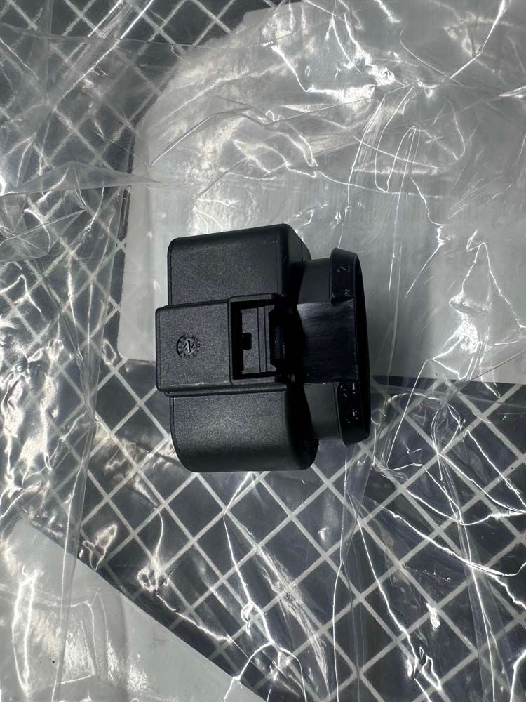 A small black object is sitting on top of a plastic bag.