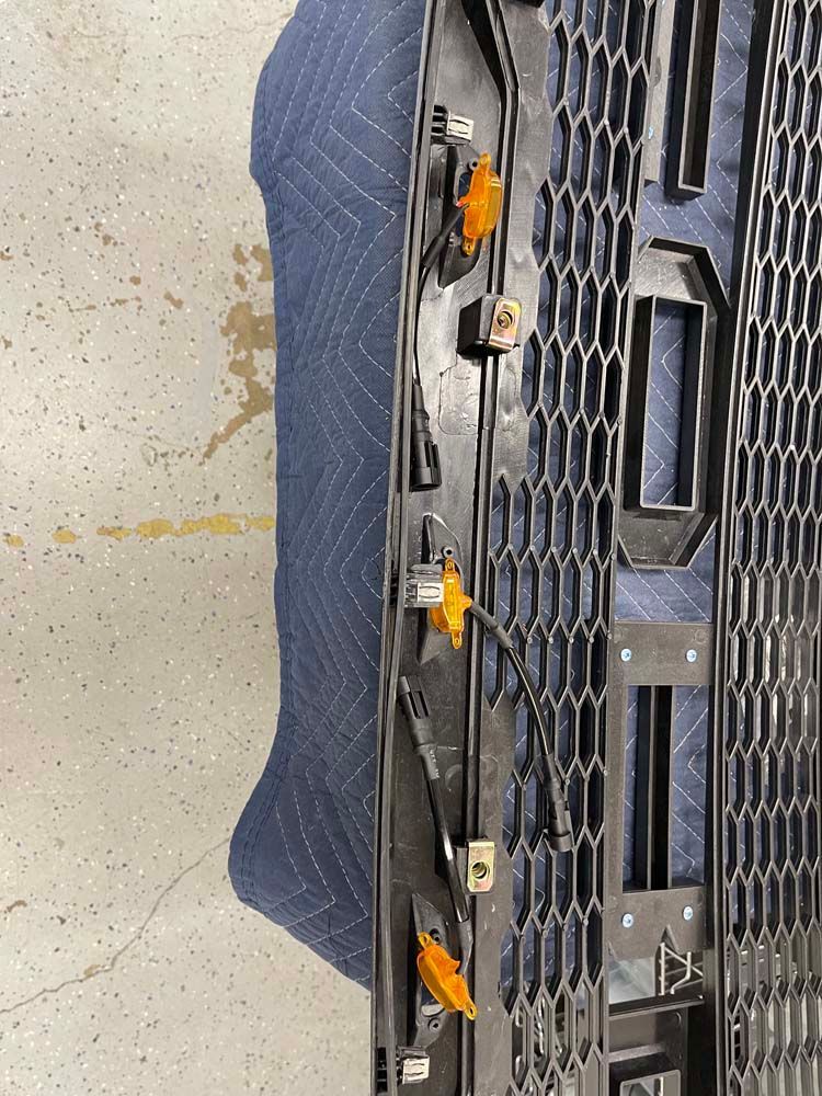 A black grille is sitting on top of a blue blanket.