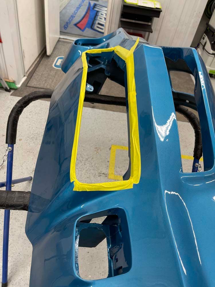 A blue bumper with yellow tape on it is sitting on a stand.