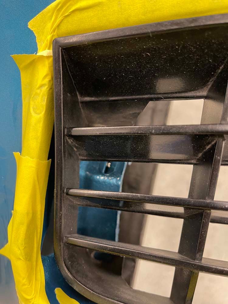 A close up of a car grill with yellow tape on it