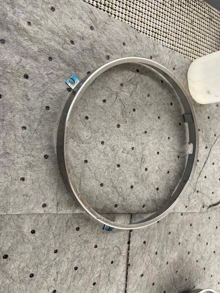 A metal ring is sitting on top of a gray surface.