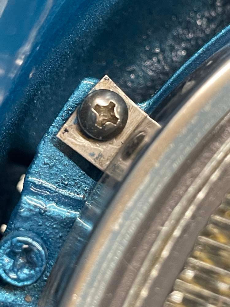 A close up of a screw on a car headlight.
