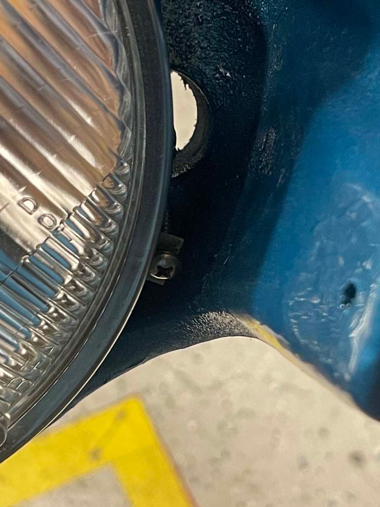 A close up of a headlight on a blue car.