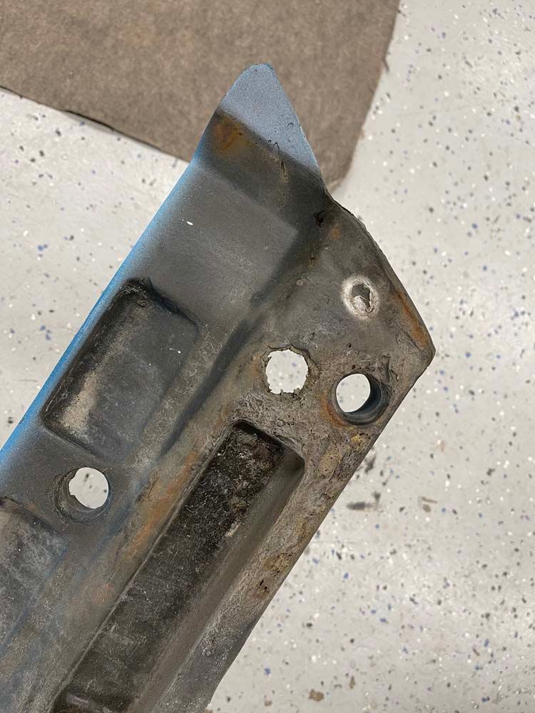 A piece of metal with holes in it is sitting on a white surface.