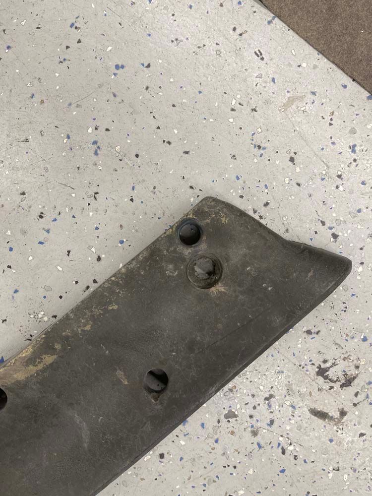 A piece of metal is sitting on top of a white surface.