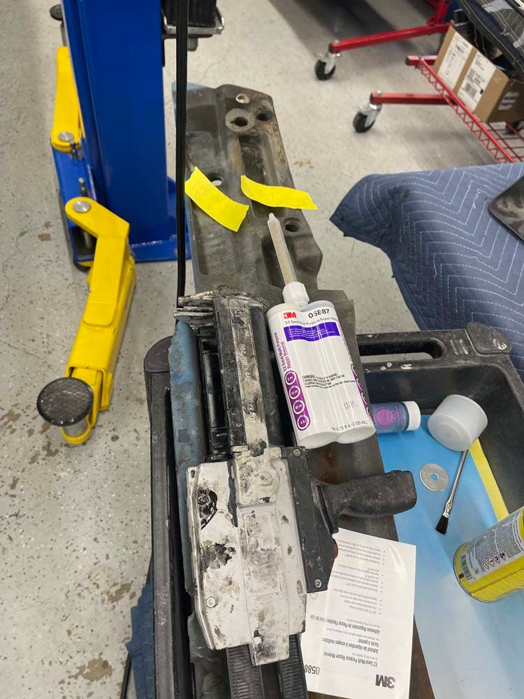 A bottle of 3m sealant is sitting on top of a piece of metal.