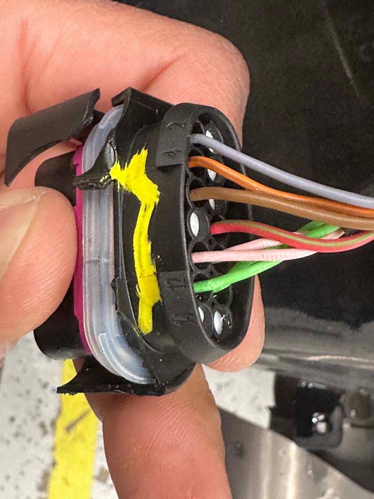 A person is holding a connector with wires attached to it