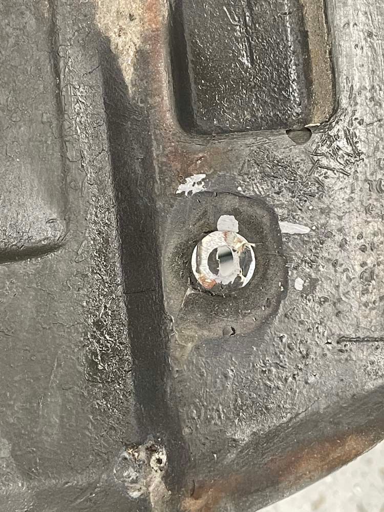 A close up of a metal object with a screw in it.