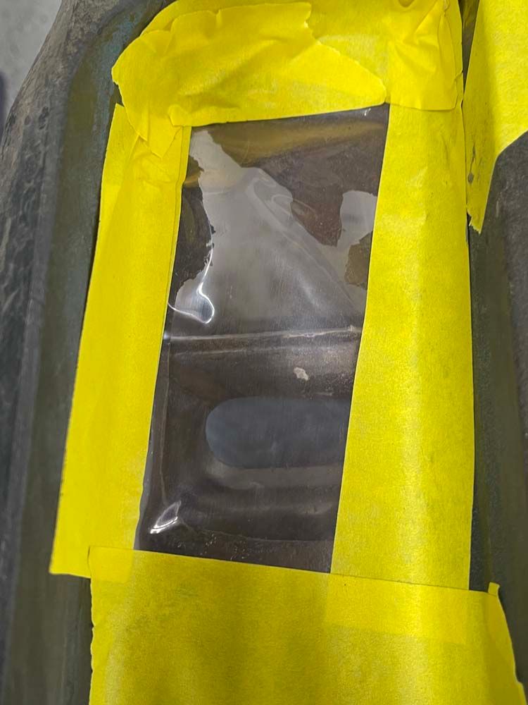 A piece of yellow tape is covering a plastic bag.