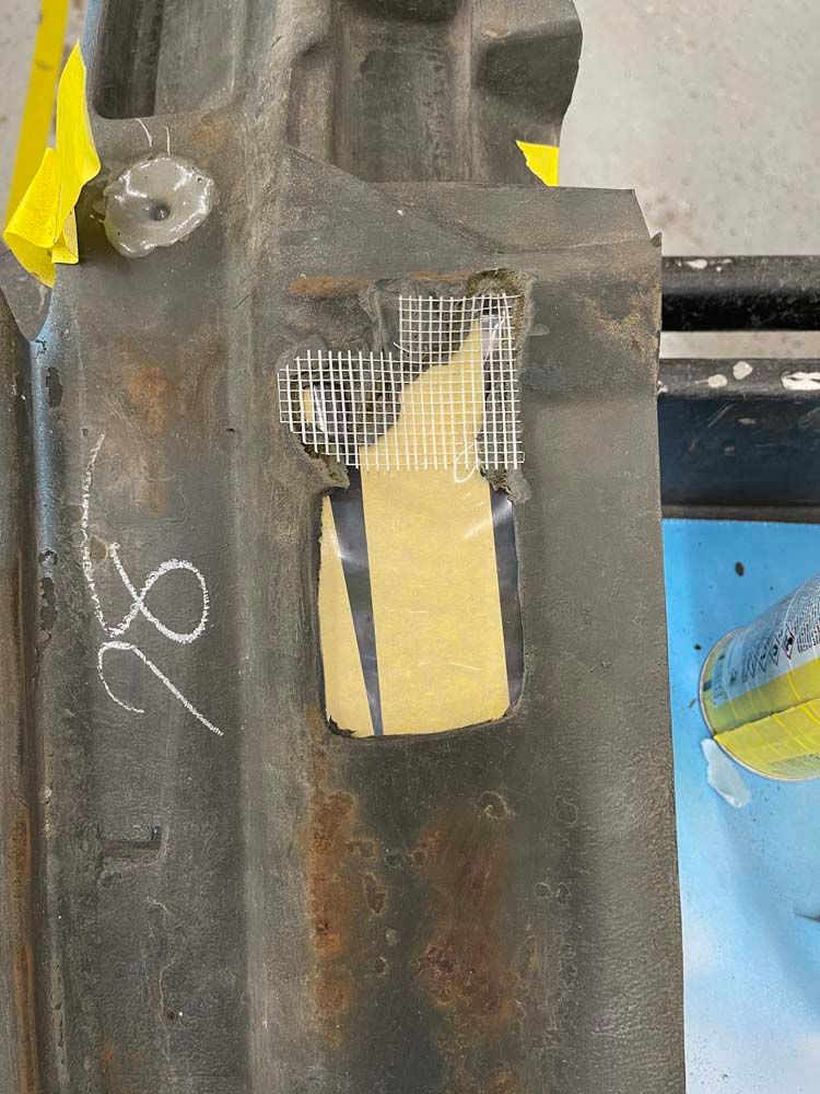 A piece of metal with a hole in it and a piece of tape on it.