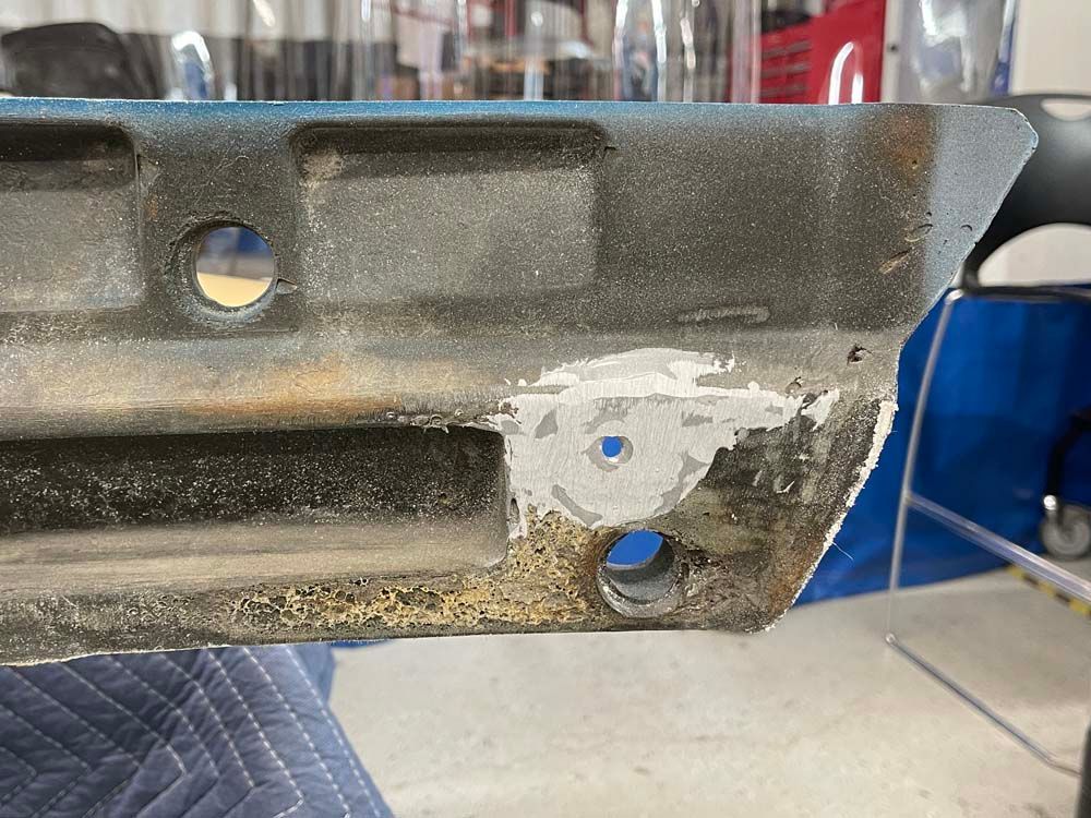 A piece of metal with holes in it is sitting on a table.